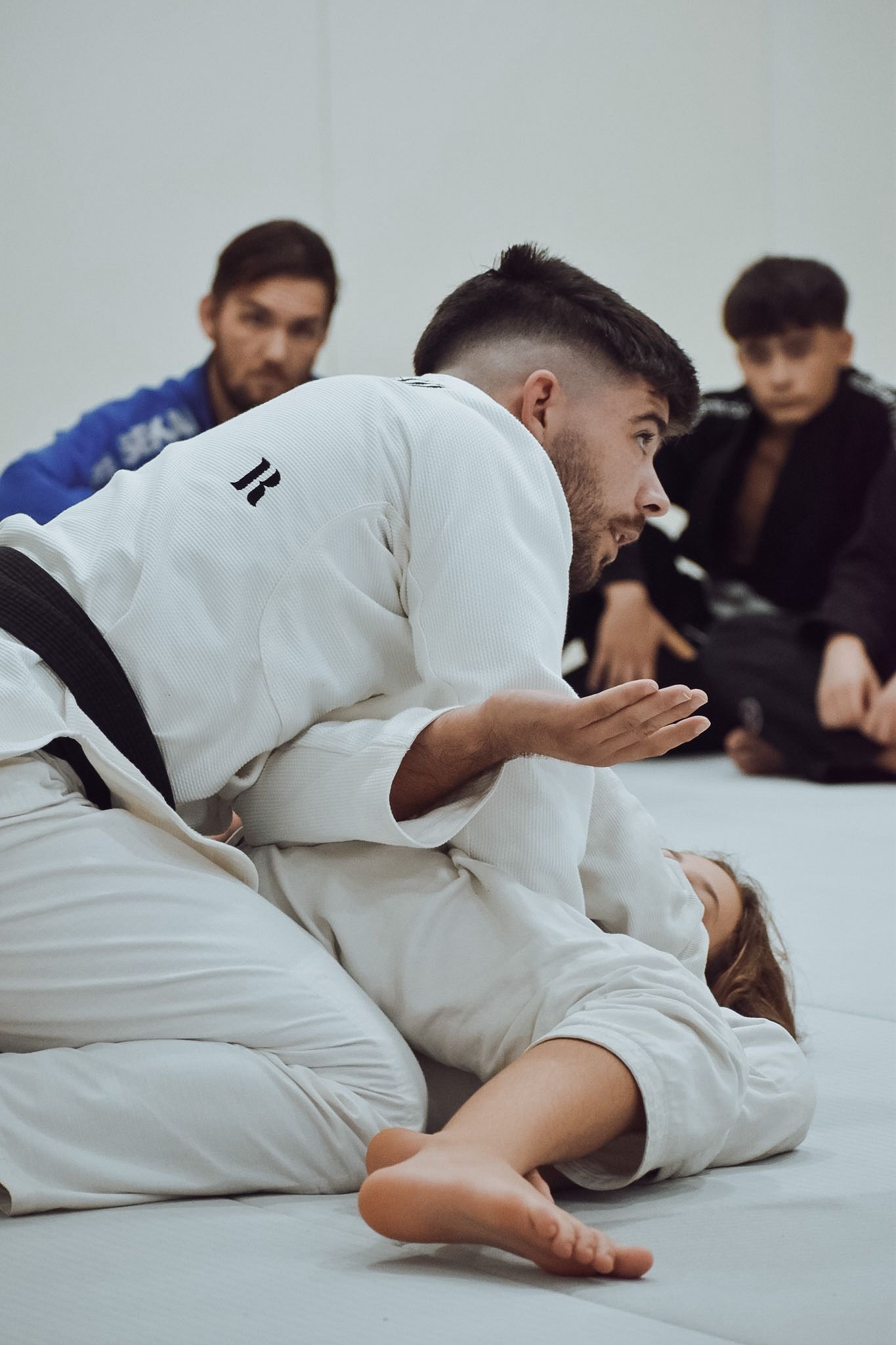 Profesor explicando una técnica a los alumnos sobre el tatami